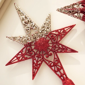 Close-up of a red and silver hollow-out Christmas tree topper star with glitter coating