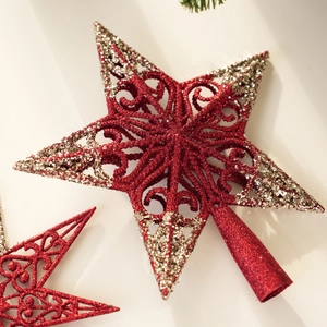 Close-up of red and gold glitter hollow star topper for Christmas tree decoration