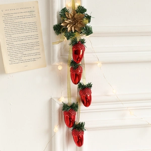 Christmas pine cone hanging ornament with red acorns and gold flower on festive background