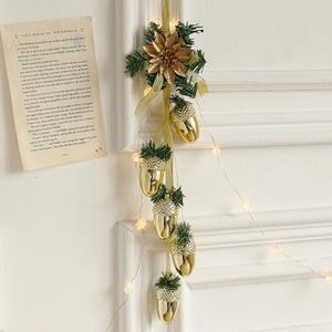 Christmas gold pine cone ornament with LED warm lights and artificial pine on a white wall
