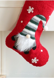 Detail of plush Christmas stocking showing red sherpa fabric and a cute gnome applique