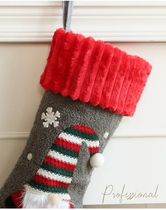 Detail of plush Christmas stocking featuring a 3D gnome with a striped hat and red collar