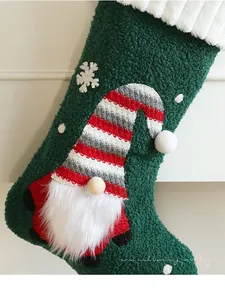 Detail of plush green Christmas stocking with gnome motif and snowflake texture