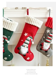 Detail of three plush Christmas stockings with 3D gnomes hanging on a white mantel