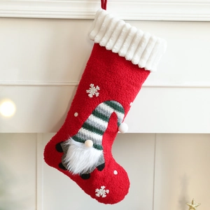 Christmas stocking with red base and plush gnome design for festive holiday decoration