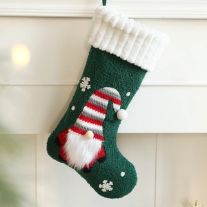 Green knit Christmas stocking featuring a plush gnome and snowflake embroidery decor