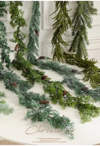 Detailed view of artificial Christmas pine garland with natural pinecones on marble surface