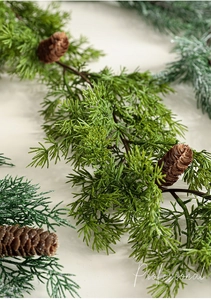 Close-up of realistic green PE pine needles and natural brown pine cones for decor