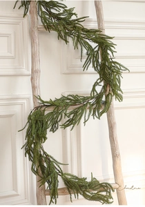 Close-up of artificial pine garland hanging on wood ladder for Christmas home decoration