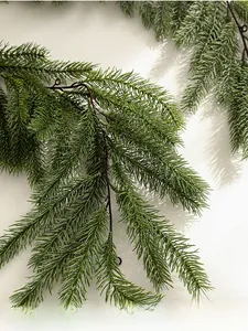 Close-up of realistic green artificial PE pine needles for Christmas wall decor