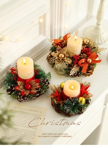 Detail of Christmas candle ring with pine cones, red berries and gold leaves decor