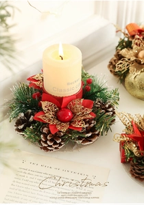 Detail of Christmas candle holder with pine cones, red berries and gold glitter flowers