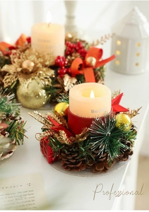 Close-up of Christmas candle holders with pine cones, red berries and golden flowers