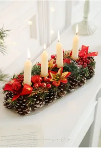 Close-up of a Christmas candle holder with pine cones, red berries, and white pillar candles