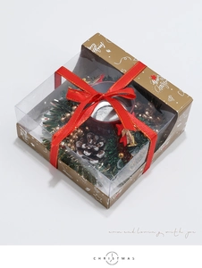 Detailed view of Christmas candle gift box with pine cones, red ribbon and festive wreath