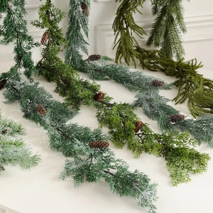 Artificial Christmas cedar garland with pine cones and flocked snow for festive wall decor