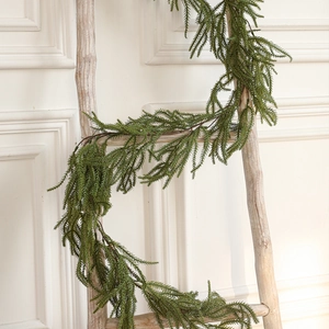 Realistic artificial cedar garland hanging on a wooden ladder for holiday wall decor