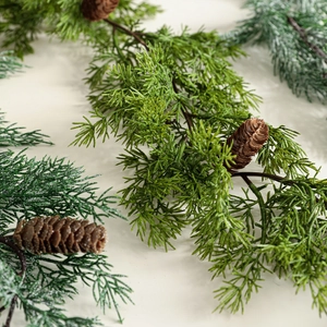 Realistic artificial cedar garland with green pine needles and pine cones for Christmas decor