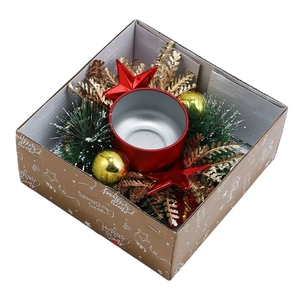 Christmas gift box with red metal candle holder, pine cone wreath and festive ornaments