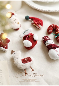 Dettaglio degli ornamenti natalizi in feltro rosso e bianco con ricami rifiniti