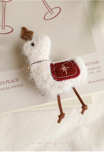 Dettaglio macro di un ornamento natalizio a forma di lama bianco con sella rossa