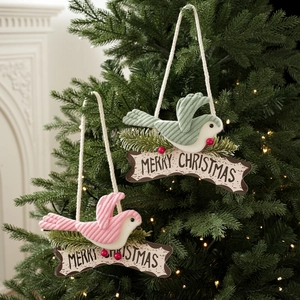Plush Christmas bird ornaments with Merry Christmas wooden sign on a festive tree