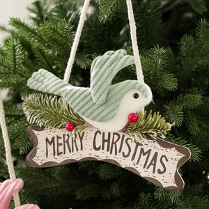 Detailed close-up of a green corduroy bird ornament with Merry Christmas sign on a tree