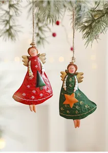 Close-up of vintage metal Christmas angel ornaments with hand-painted star and tree details