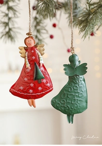 Detailed view of red and green vintage metal angel ornaments with rustic embossed patterns