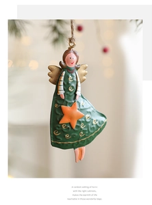 Detail of vintage iron angel ornament with textured green dress and golden wings