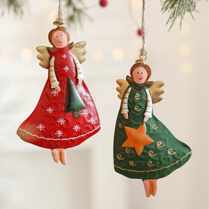 Set of two vintage iron Christmas angel ornaments hanging on a festive tree branch