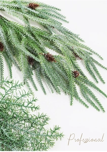 Close-up of frosted artificial pine branch with green needles and small pinecones