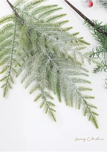 Close-up of artificial pine needle branch with realistic snow flocking for Christmas decor