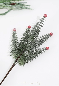 Detail of snowy PE pine needles with bright red berries for Christmas tree decoration