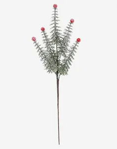 Macro detail of artificial Christmas pine branch with red berries and snowy flocking decor