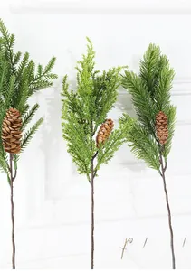 Detailed view of three artificial pine branches with green needles and realistic pine cones