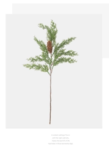 Detailed view of artificial pine branch with green needles and a brown pine cone