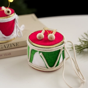 Nahaufnahme von roten und grünen Trommel-Weihnachtshängern mit goldenen Schnüren und Sticks