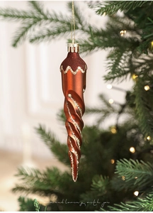 Detail of copper spiral icicle Christmas ornament with glitter lines on tree branch
