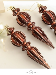 Detail of brown flocked icicle ornaments with gold glitter stripes for Christmas tree