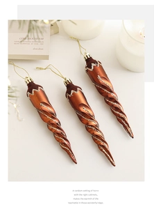 Close-up of three brown spiral icicle ornaments with gold glitter and white wave details