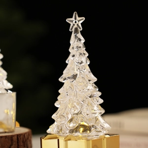 Macro view of crystal Christmas tree with star topper and glowing golden base