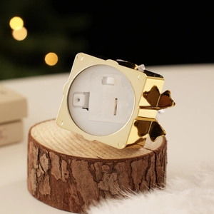 Detail view of the golden gift box ornament base with on/off switch and battery compartment