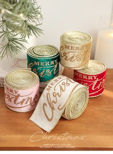 Detail of velvet Christmas ribbons with gold glitter Merry Christmas lettering on wood