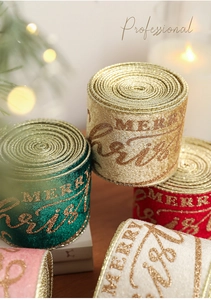Detail of velvet Christmas ribbons with gold Merry Christmas print and woven edges