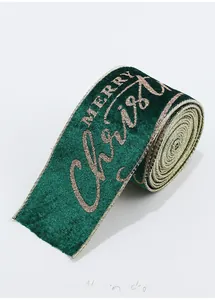 Close-up of green velvet Christmas ribbon with gold glitter Merry Christmas lettering
