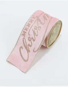 Close-up of pink velvet Christmas ribbon with gold glitter Merry Christmas text