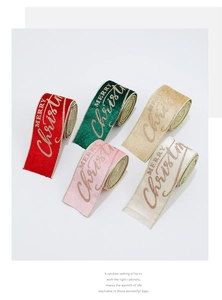 Macro detail of Merry Christmas glitter print on multi-color velvet ribbon rolls
