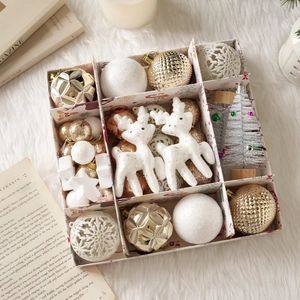 Coffret de décorations de Noël détaillé avec boules dorées et blanches, cerfs et étoiles