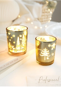 Vue détaillée des photophores en verre ambré avec motifs festifs de sapin et de renne